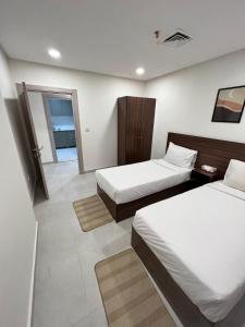 una camera d'albergo con due letti e un bagno di برج ماجيك سويت Magic Suite Tower a Kuwait