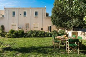 a table and chairs in front of a building at Masseria Baroni in Casa Bonivini