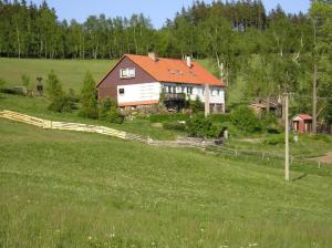 una casa con tetto arancione in un campo di MariePavla a Jáchymov