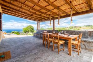 an outdoor dining area with a wooden table and chairs at Sa Domo Isola Rossa in Trinità d'Agultu e Vignola