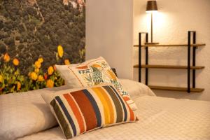 uma cama com duas almofadas e uma parede com flores em Sa Domo Isola Rossa em Trinità d'Agultu e Vignola