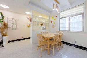 a dining room with a wooden table and chairs at Xi Valley Apartment in Zhangjiajie