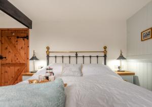 ein Schlafzimmer mit einem weißen Bett und einer Holztür in der Unterkunft Cwtch Honey in Lampeter