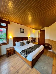 1 dormitorio con 1 cama grande y techo de madera en Wingait Inn - Hotel Near The Mall Road, en Shimla