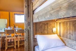 una camera con letto a castello e tavolo di Luxury Lodge Glamping a Palazzolo dello Stella