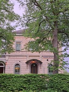 un edificio de ladrillo con un árbol delante de él en Hotel am Prinzengarten en Sigmaringen