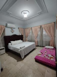 um quarto com uma cama grande e um cobertor rosa em Vila Princess,Sentul 4br, private pool, tenis meja, mini billiard, Home theater Karaoke, Ayunan besar,BBQ, 08satu3 80satu6 4satu5satu em Bogor