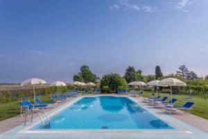 uma grande piscina com cadeiras e guarda-sóis em Luxury Lodge Glamping em Palazzolo dello Stella