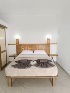 a bedroom with a bed with a sign on it at Sun Day Apartments Free Airport Shuttle in Artemida
