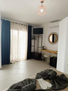 a living room with a bed and a mirror at Sun Day Apartments Free Airport Shuttle in Artemida