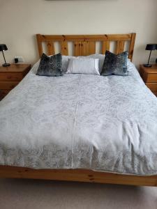 a bed with a wooden frame and pillows on it at Charming 1-Bed Apartment in Barefield in Ennis