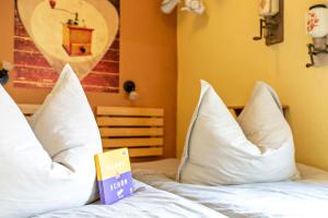um livro em cima de uma cama com almofadas em Ferienwohnung Kaffeemühle em Flensburg