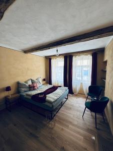 a bedroom with a bed in a room with windows at Original Trebic whisky bar Room in Třebíč