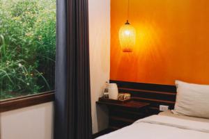- une chambre avec un mur orange, un lit et une fenêtre dans l'établissement De Amor House & Coffee, à Sa Pa