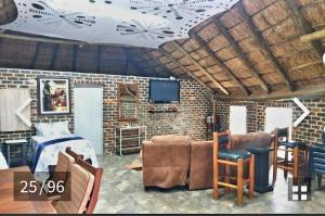 ein Wohnzimmer mit einem Sofa und einem TV in der Unterkunft Midvaal Guesthouse in Meyerton