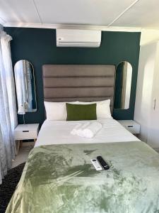 ein Schlafzimmer mit einem großen Bett mit zwei Fernbedienung in der Unterkunft The legacy BnB in East London