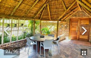 a patio with a table and chairs and a wooden door at Midvaal Guesthouse in Meyerton