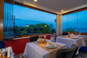 un restaurante con 2 mesas y una gran ventana en Harmony Hotel Istanbul & SPA, en Estambul