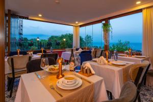 イスタンブールにあるHarmony Hotel Istanbul & SPAの海の景色を望むテーブルと椅子付きのレストラン