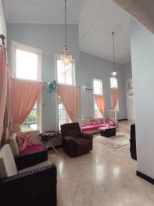 a living room with couches and chairs and windows at Vila Princess,Sentul 4br, private pool, tenis meja, mini billiard, Home theater Karaoke, Ayunan besar,BBQ, 08satu3 80satu6 4satu5satu in Bogor