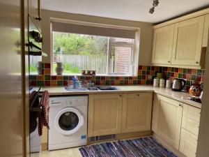 een keuken met een wasmachine en een wastafel bij Wensleydale Stone Cottage in Hunton