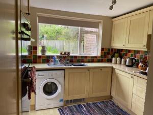 a kitchen with a washing machine and a sink at Wensleydale Stone Cottage in Hunton +12 photos