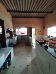 eine große Küche mit weißen Fliesenböden und einer Decke in der Unterkunft BiaMar in Luminárias