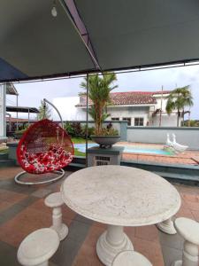 eine Terrasse mit einem Tisch, Stühlen und einem Vogel in der Unterkunft Vila Princess,Sentul 4br, private pool, tenis meja, mini billiard, Home theater Karaoke, Ayunan besar,BBQ, 08satu3 80satu6 4satu5satu in Bogor