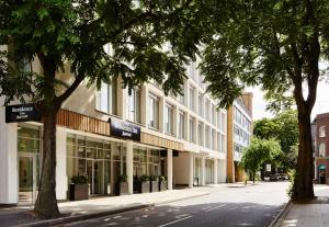 un edificio en una calle con árboles delante en Residence Inn by Marriott London Bridge, en Londres