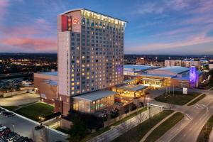 ein hohes Gebäude mit einer Uhr darüber in der Unterkunft Sheraton Overland Park Hotel at the Convention Center in Overland Park