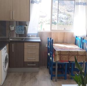 a small kitchen with a table and a sink at Casa Faican in Agaete