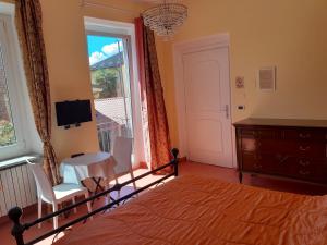 um quarto com uma cama, uma mesa e uma janela em "B&B Sans égal", con camere private e appartamenti al piano terra a Biella em Biella