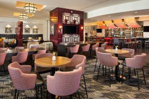 a restaurant with tables and chairs and a bar at Sheraton Overland Park Hotel at the Convention Center in Overland Park