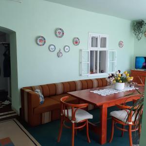 ein Wohnzimmer mit einem Sofa und einem Tisch in der Unterkunft Marika vendégház in Abádszalók