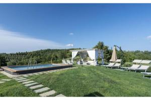 une arrière-cour avec une piscine et une pelouse avec des chaises longues dans l'établissement Villa Zara, à Palaia