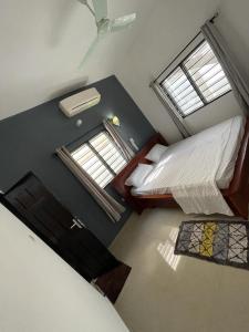 Abomey-CalaviにあるVilla 2 chambres salonのベッド2台と窓2つが備わる小さな客室です。