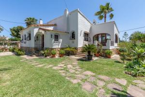 a large white house with a grass yard at Villa Maria in Jávea