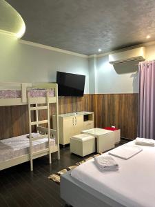 a room with two bunk beds and a flat screen tv at Imperium Hotel in Tirana +43 photos