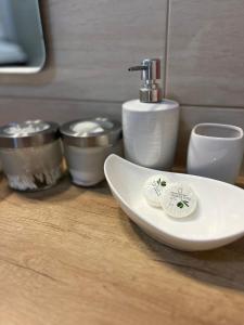 a white sink sitting on a wooden counter with containers at Apartments Romano in Dubrovnik