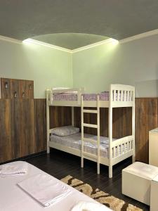 two bunk beds in a room with wooden walls at Imperium Hotel in Tirana