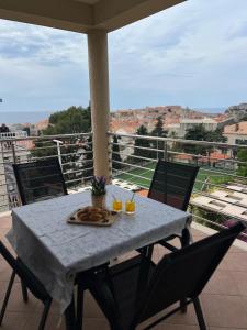 a table with a plate of food on a balcony at Apartments Romano in Dubrovnik