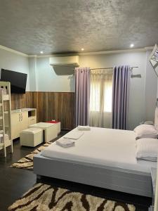 een slaapkamer met een groot wit bed in een kamer bij Imperium Hotel in Tirana