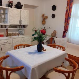 eine Küche mit einem Tisch und einer Blumenvase darauf in der Unterkunft Marika vendégház in Abádszalók