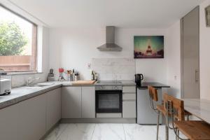 cocina blanca con fregadero y fogones en Double Room in Maida Vale, en Londres