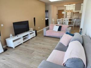 a living room with a couch and a flat screen tv at Isa Charme Home in Praia