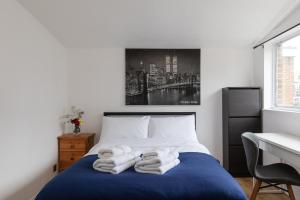 1 dormitorio con 1 cama con toallas en Double Room in Maida Vale, en Londres