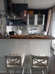 a kitchen with two chairs sitting at a counter at Ferien zwischen den Meeren in Jübek
