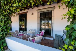 eine Terrasse mit Stühlen und einem Tisch vor einem Gebäude in der Unterkunft Habitaciones El Rocio in El Rocío