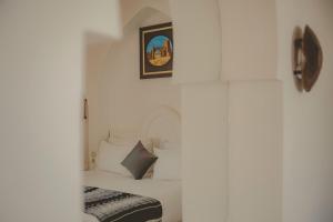 - une chambre avec un lit et une photo sur le mur dans l'établissement Palais Des Remparts, à Essaouira