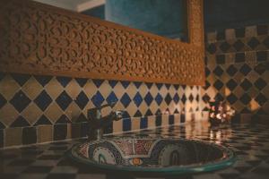 a sink in a bathroom with a tiled wall at Palais Des Remparts in Essaouira